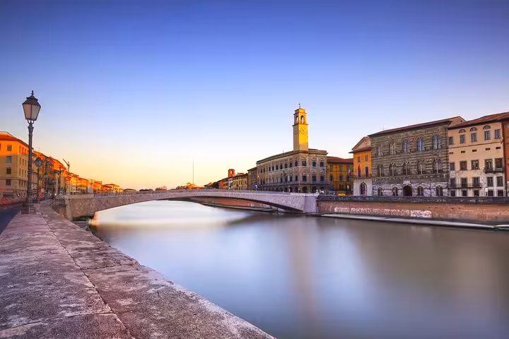 Scenic view of Arno River and historic Pisa architecture during sunset, part of the Pisa private tour from Florence.