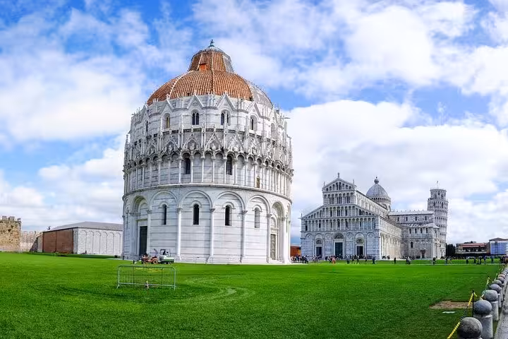 View of Pisa's Baptistery and Cathedral under a blue sky, part of a private half-day tour from Florence.