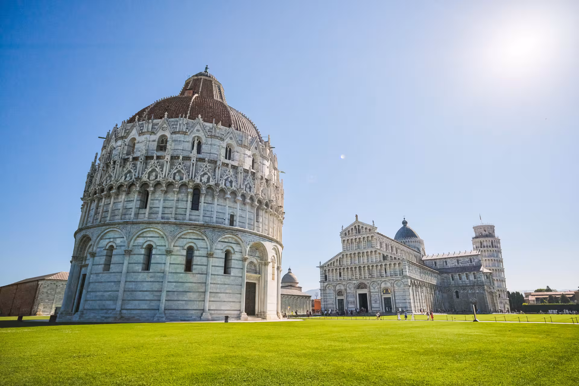 Panoramic view of Pisa Baptistery, Cathedral, and Leaning Tower on a sunny day during a tour from Florence.