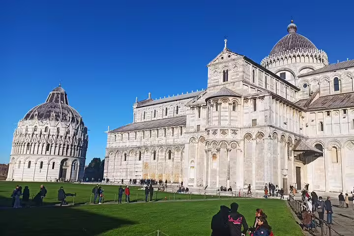 Tourists exploring Pisa Cathedral and Baptistery on a sunny day, included in private Pisa and Chianti wine tour