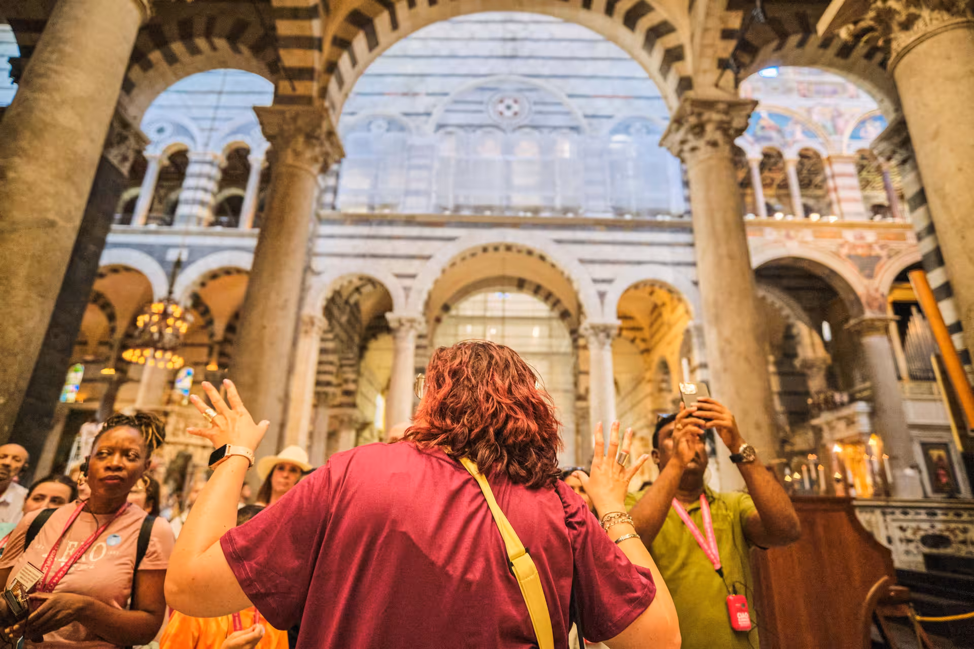 Tourists explore the ornate interior of Pisa Cathedral during a guided half-day tour from Florence, marveling at its architecture.
