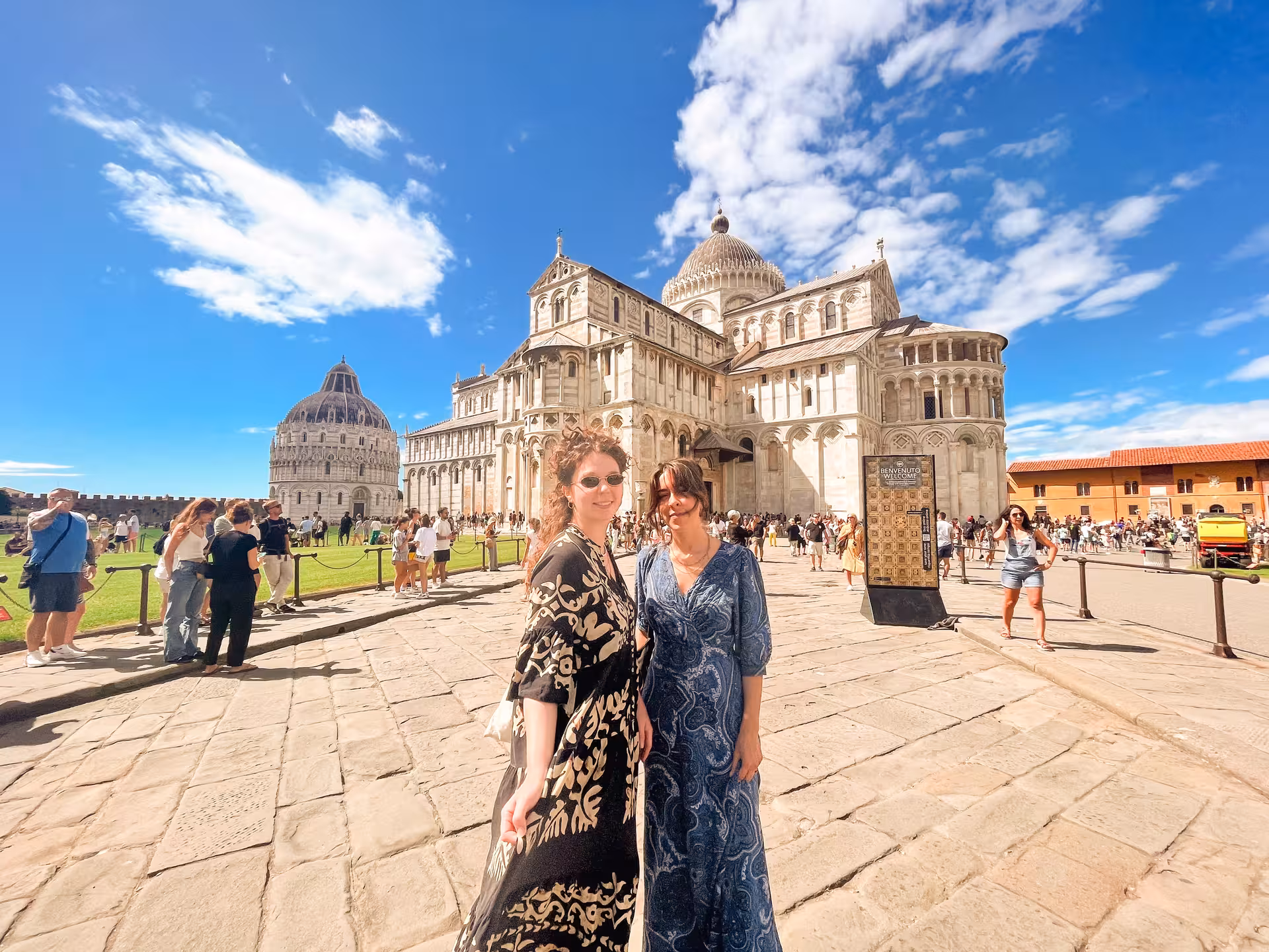 Tourists enjoying a sunny day at the Pisa Cathedral Square during a private tour from Florence.