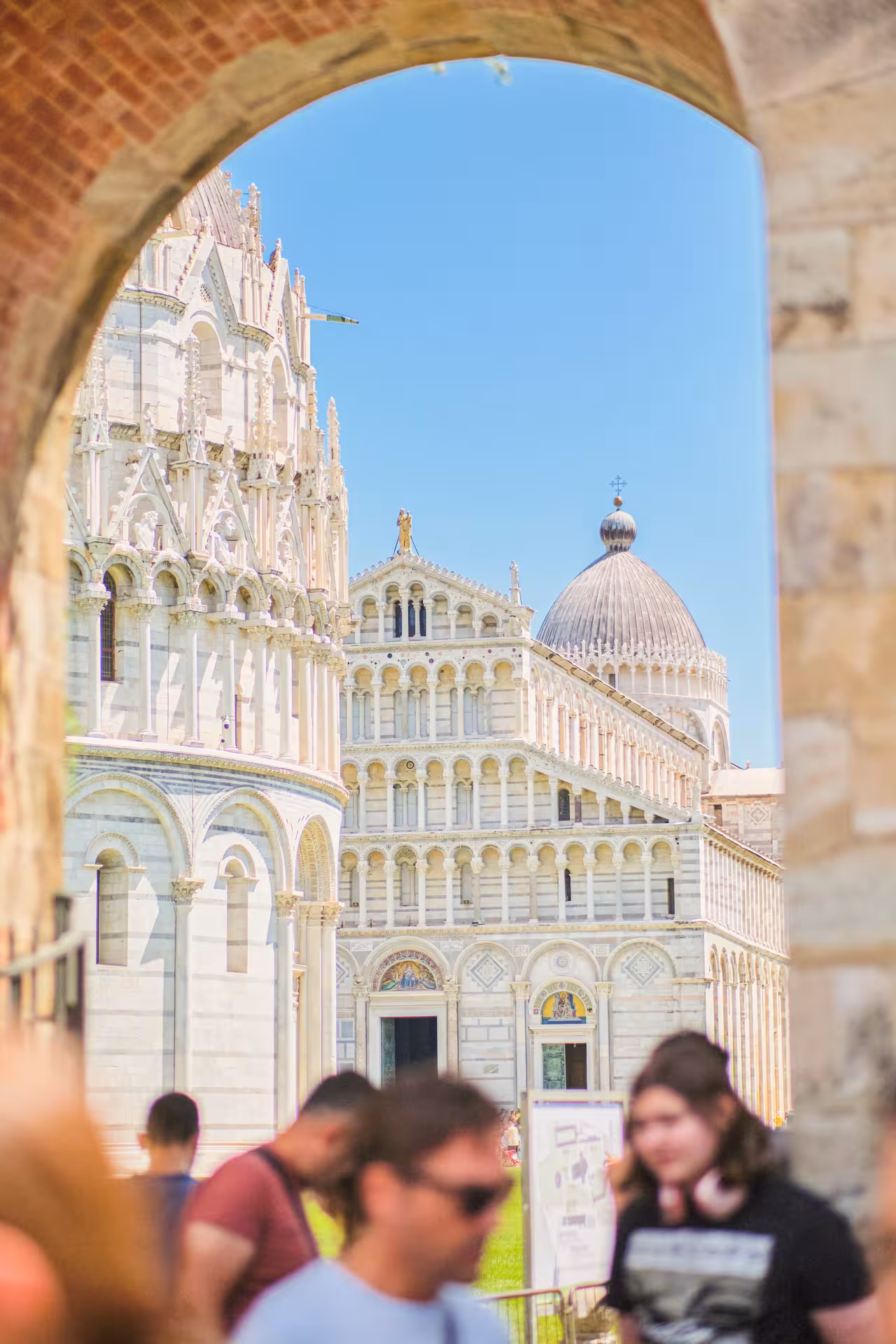 Iconic Pisa Cathedral and Baptistery viewed through an archway, capturing the essence of a Livorno shore excursion.
