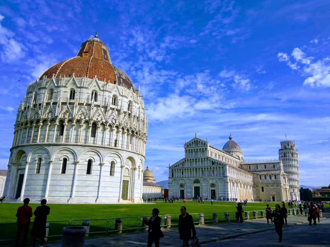 Iconic Pisa landmarks including the Leaning Tower, captured on an eco-friendly electric minibus tour under a clear blue sky.