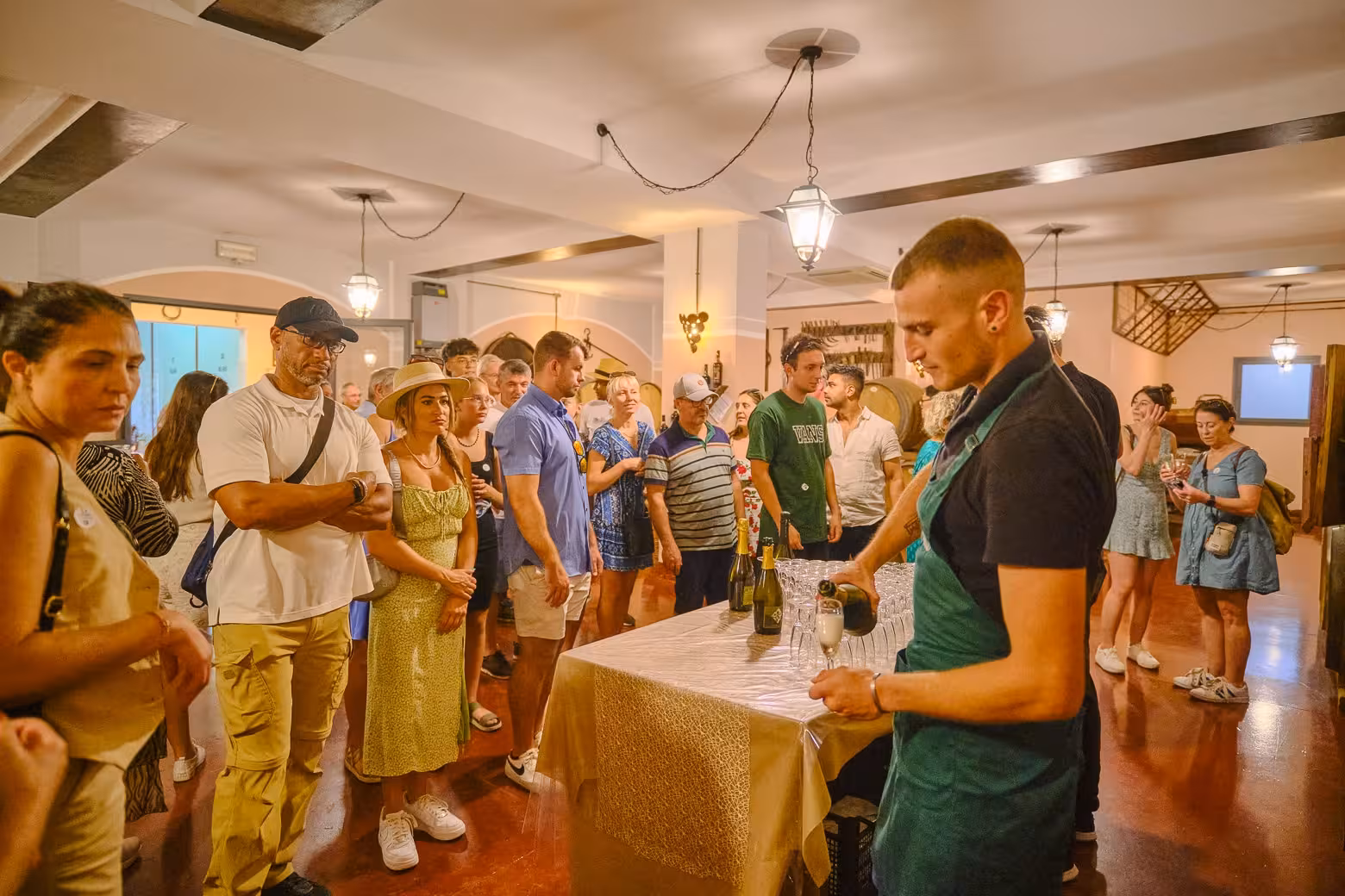 Tour group enjoying a wine tasting session indoors, highlighting the Pisa, Siena, and San Gimignano day trip experience.