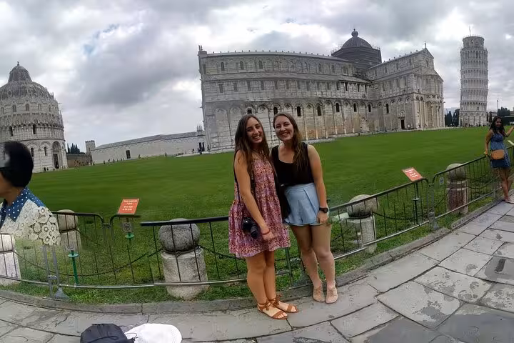 Two visitors posing in front of Pisa's historic landmarks, highlighting a memorable stop on the Tuscany tour.