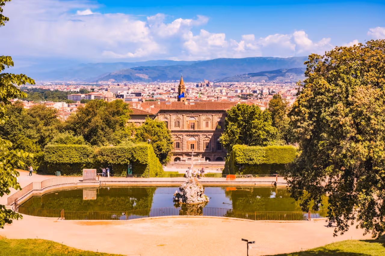 Scenic view of Pitti Palace and Boboli Gardens with Florence skyline in the background on a sunny day.