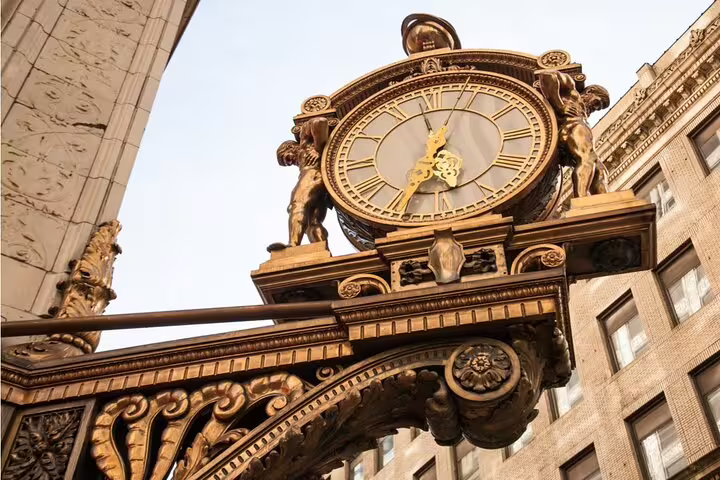 Ornate gold antique clock with Roman numerals mounted on decorative ironwork in Pittsburgh