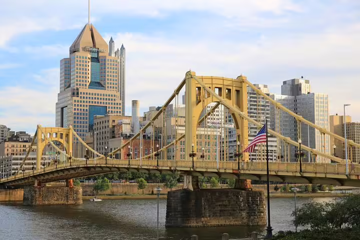 Yellow Roberto Clemente Bridge over Allegheny River with Pittsburgh skyline skyscrapers in background