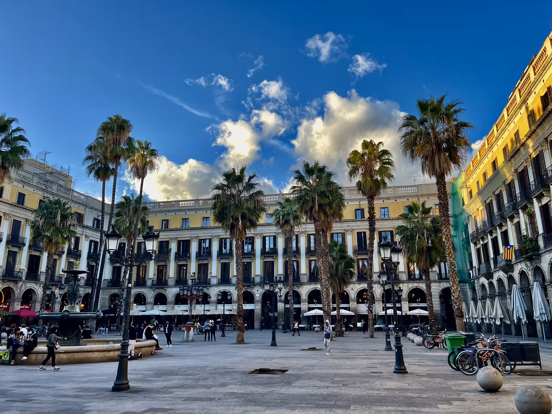 Plaça Reial in Barcelona with palm trees and arcades, a scenic stop on Encantos Locales city walk
