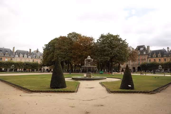 Wide view of Place des Vosges gardens and central fountain in Le Marais, Paris on a private walking tour