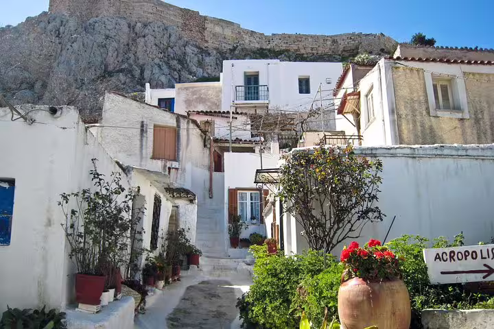 Plaka alley under the Acropolis, whitewashed houses and flowers on Athens at night walking tour with dinner
