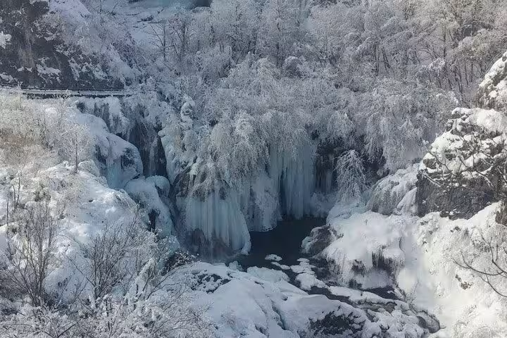 Frozen Plitvice Lakes waterfall and snowy forest scenery on a winter private tour from Zagreb with Rastoke