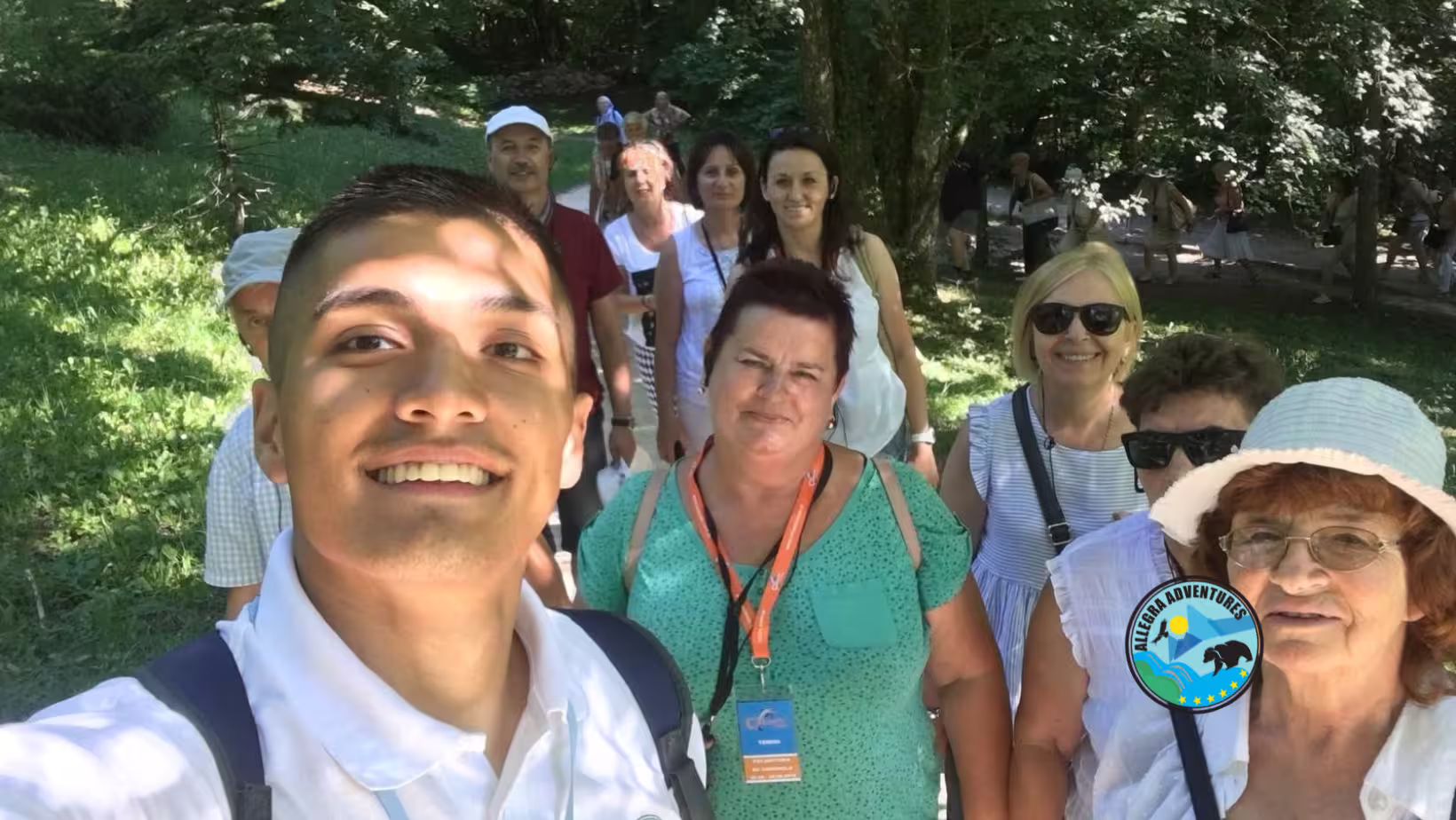 Tour guide selfie with guests on forest trail at Plitvice Lakes, secured tickets tour with train and boat ride