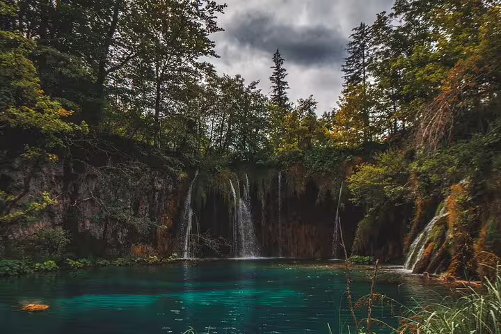 Moody forest waterfalls and emerald lake at Plitvice Lakes, Croatia on a scheduled economy day tour