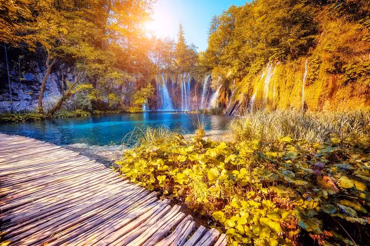 Wooden boardwalk by Plitvice Lakes waterfalls and crystal-clear pools on private Zadar to Zagreb tour