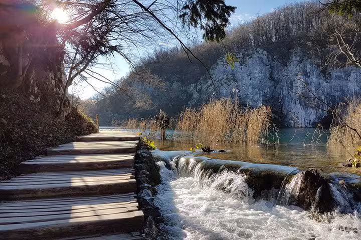 Wooden boardwalk beside rushing water at Plitvice Lakes National Park on a Zagreb small group day trip