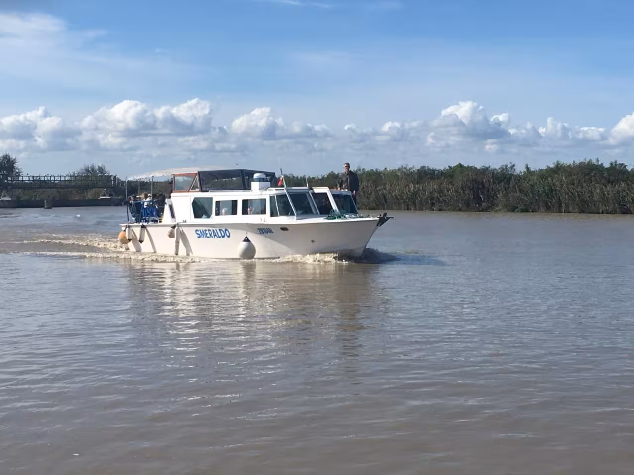 Boat cruising the Po Delta waterways on an Isola dell’Amore nature tour, panoramic river and wetlands views
