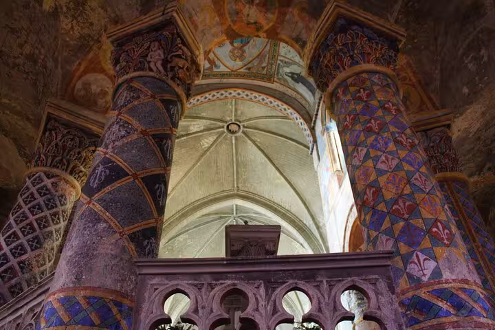 Vibrantly decorated columns inside a historic building showcasing medieval artistry in Poitiers.