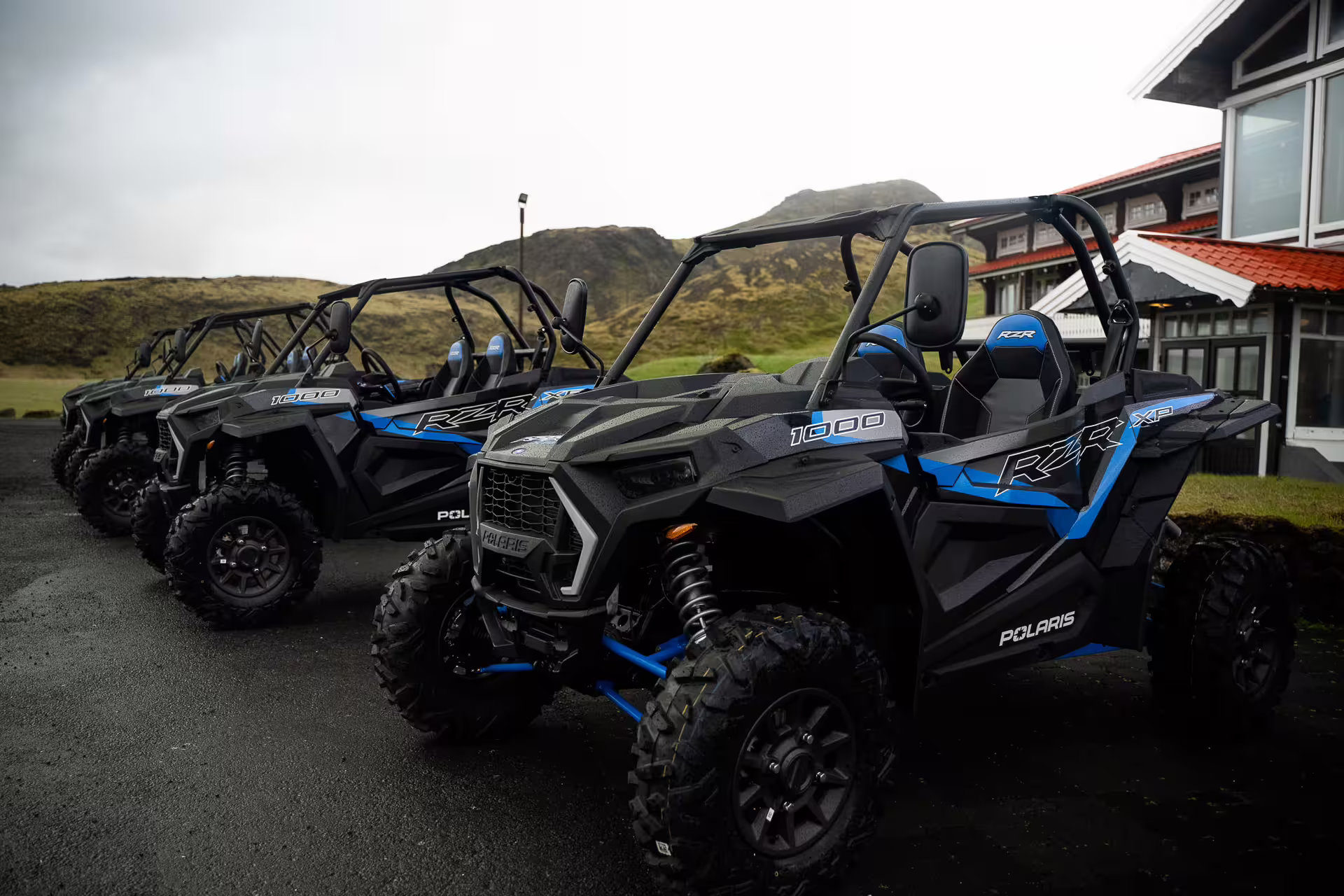 Row of Polaris RZR XP 1000 buggy vehicles parked near Icelandic hills ready for guided tour