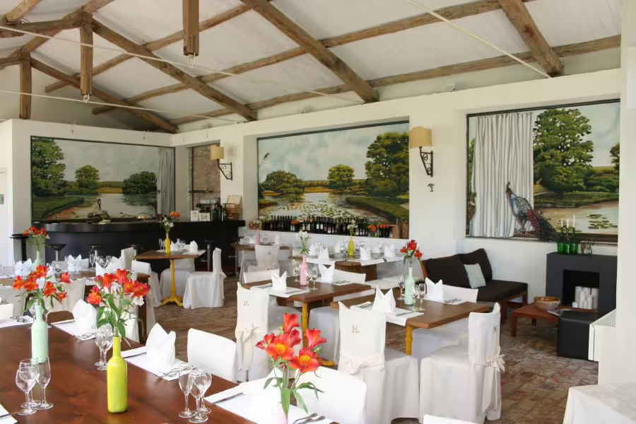 Charming rustic dining room near Pollino Park with wooden beams, floral decor and tables set for a castle retreat dinner