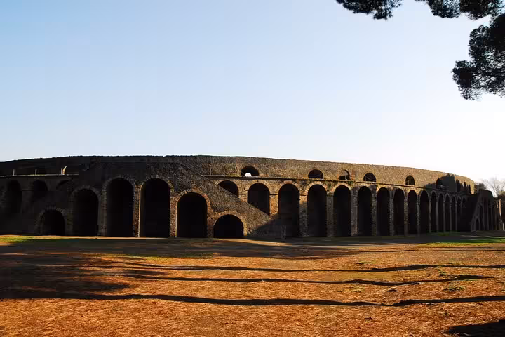 Ancient Roman amphitheater ruins with arched walls in Pompeii on a clear day