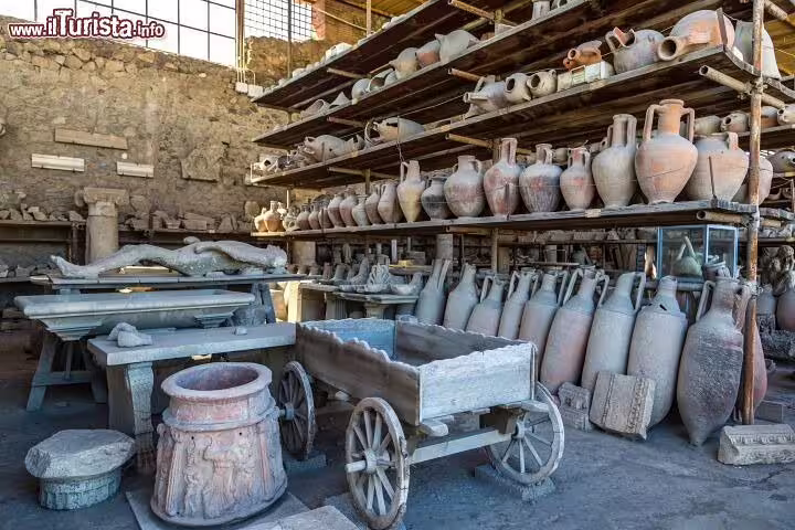 Shelves of amphorae, artifacts and wooden cart in Pompeii storage area visited on a private Positano Pompei Vesuvio tour
