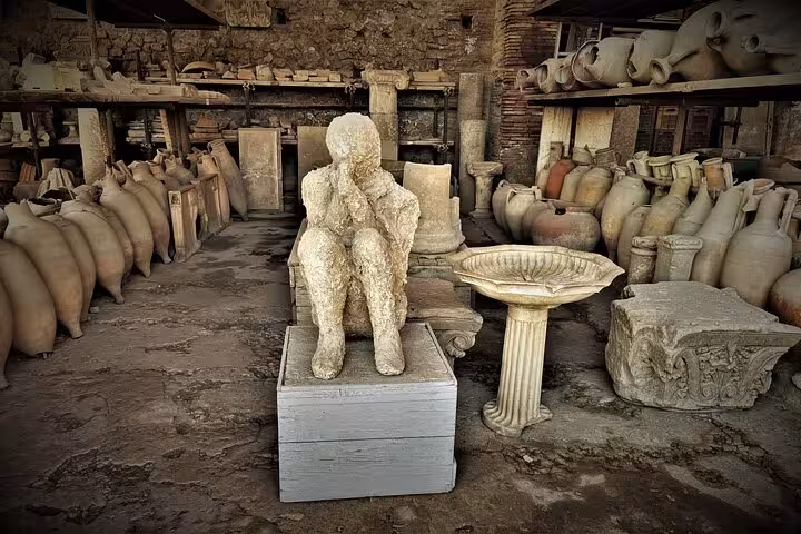 Ancient artifacts and a preserved plaster cast in the ruins of Pompeii, highlighting the site's archaeological significance.