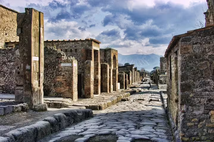 Ancient cobblestone street in Pompeii with stone buildings, ideal for VIP small-group Pompeii tour from Naples