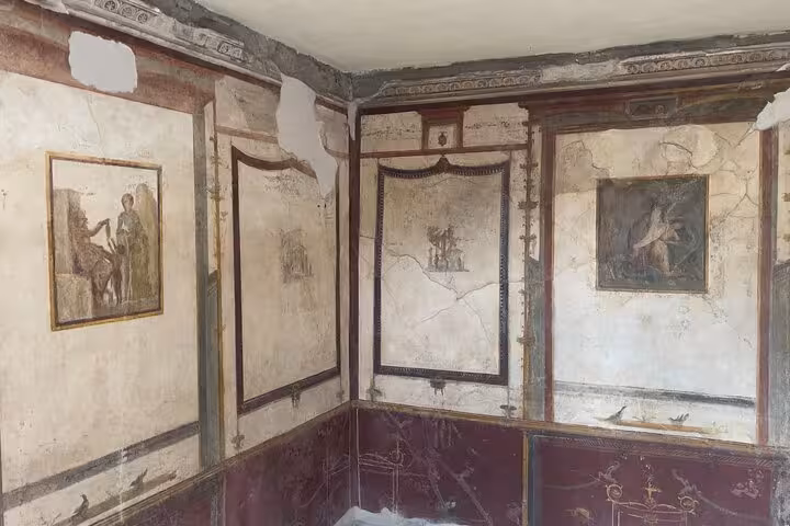 Intricate frescoes in a room from ancient Pompeii showcasing well-preserved Roman art and architecture.