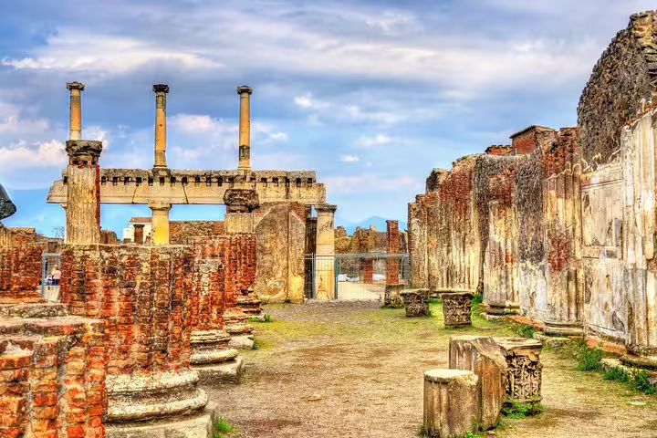 Ancient temple ruins and brick columns in Pompeii archaeological site on a private guided tour near Naples, Italy