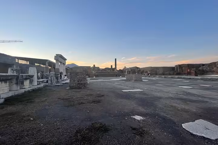 Discover Pompeii's expansive archaeological site, bathed in the soft glow of sunset, offering a serene historical experience.