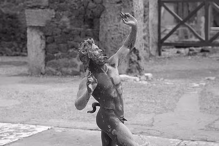 Marvel at the intricate statue of a dancing figure amidst the historic ruins of Pompeii on this guided tour.