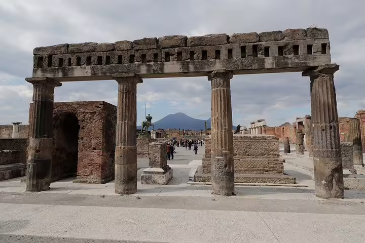 Ancient Roman columns and ruins at Pompeii Forum with Mount Vesuvius in the background