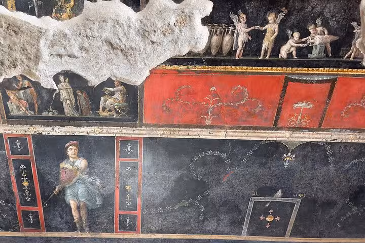Vibrant frescoes depicting mythological scenes in Pompeii, part of the Pompeii & Vesuvius tour experience.