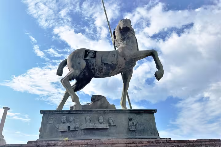 Majestic bronze centaur statue under a clear sky in Pompeii, featured in a guided tour with skip-the-line access.