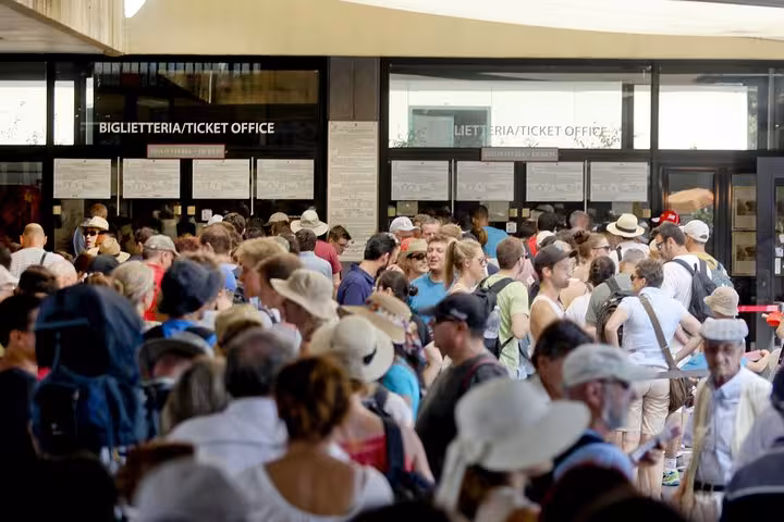 Crowd gathers at Pompeii ticket office for guided tours from Sorrento Coast, highlighting visitor demand and interest.