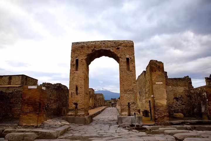 Walk through ancient Pompeii's stone archways with stunning views on a guided tour from Positano.