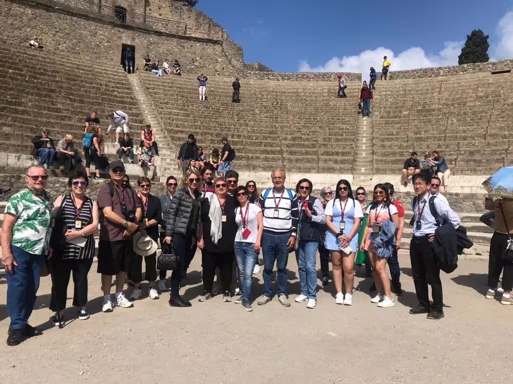 Naples group tour visitors at Pompeii amphitheatre on guided Pompeii and Herculaneum day trip