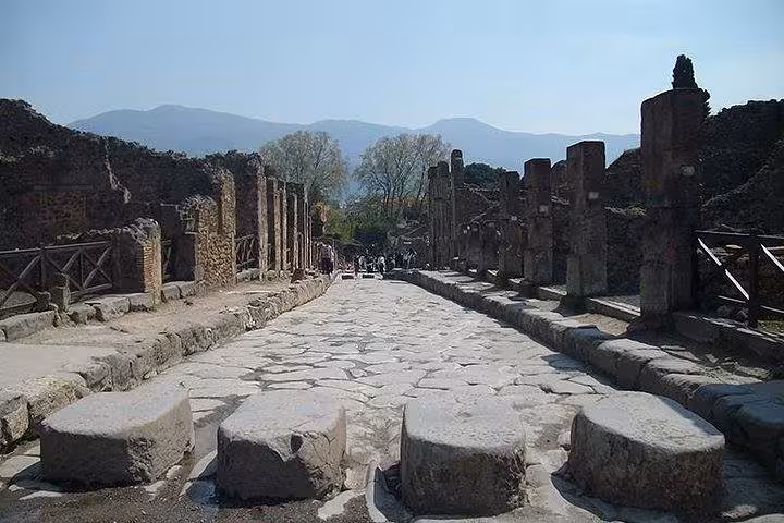 Walk along the ancient stone streets of Pompeii with stunning mountain views on a guided tour with lunch.