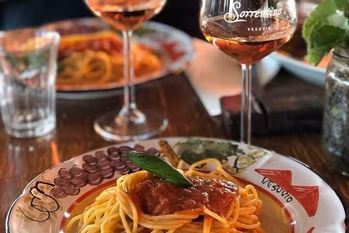 Savor authentic Italian cuisine with a classic pasta dish paired with wine during a guided tour of Pompeii and Herculaneum.