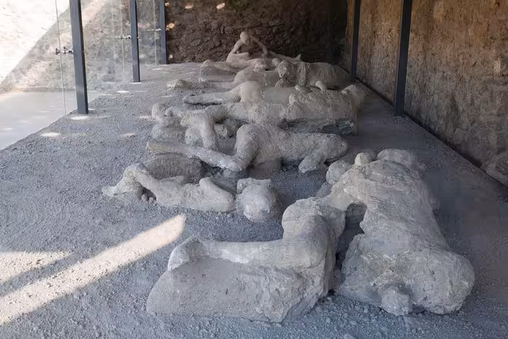 Preserved plaster casts of Pompeii victims displayed in an archaeological site on an 8-hour Hercolaneum, Pompeii, Sorrento tour.