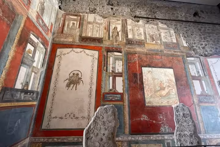 Colorful frescoes depicting Roman mythology in Pompeii, featured in the Enjoy Pompeii & Mt. Vesuvius tour experience.