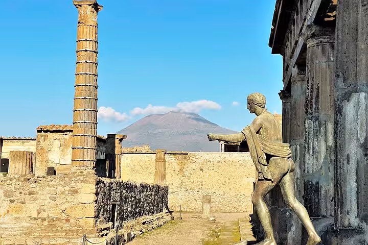 Statue and ruins at Pompeii with Mt. Vesuvius in the background, featured on the semi-private tour from Positano.