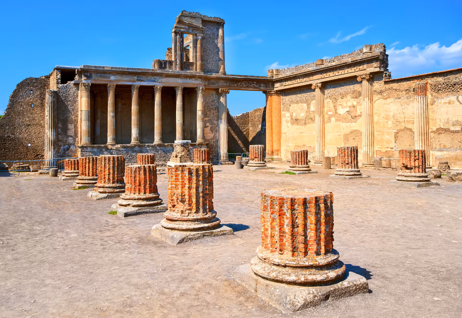 Temple ruins in Pompeii with ancient columns, part of the express prestige tour from Rome by minivan.
