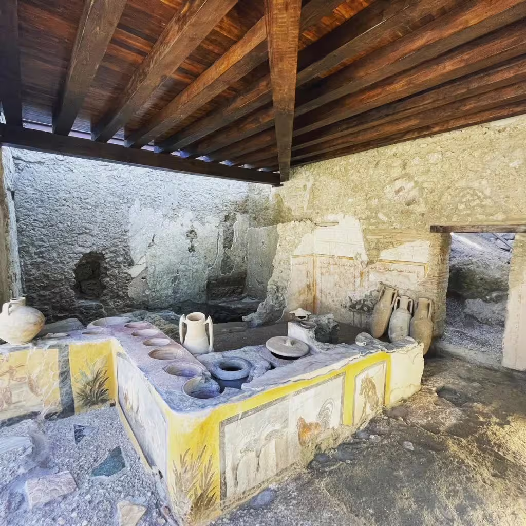 Pompeii thermopolium snack bar ruins on Naples half-day group tour, showing fresco counter and amphorae jars