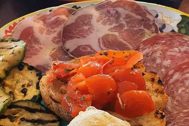 Enjoy a delicious Italian lunch with cured meats, grilled vegetables, and bruschetta during your Pompeii tour from Sorrento.