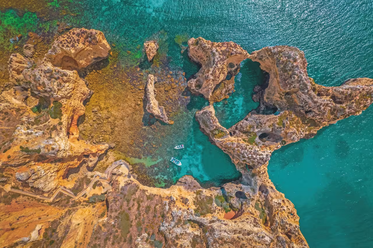 Aerial view of Lagos Algarve golden limestone rock formations and turquoise sea perfect for kayak tours