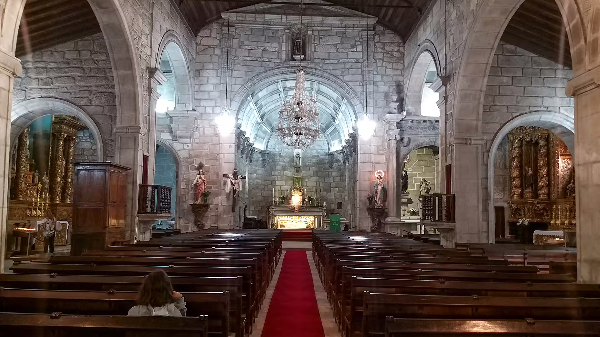 Historic stone church interior in Ponte de Lima, featuring ornate arches and chandeliers, part of the Vinho Verde private tour.