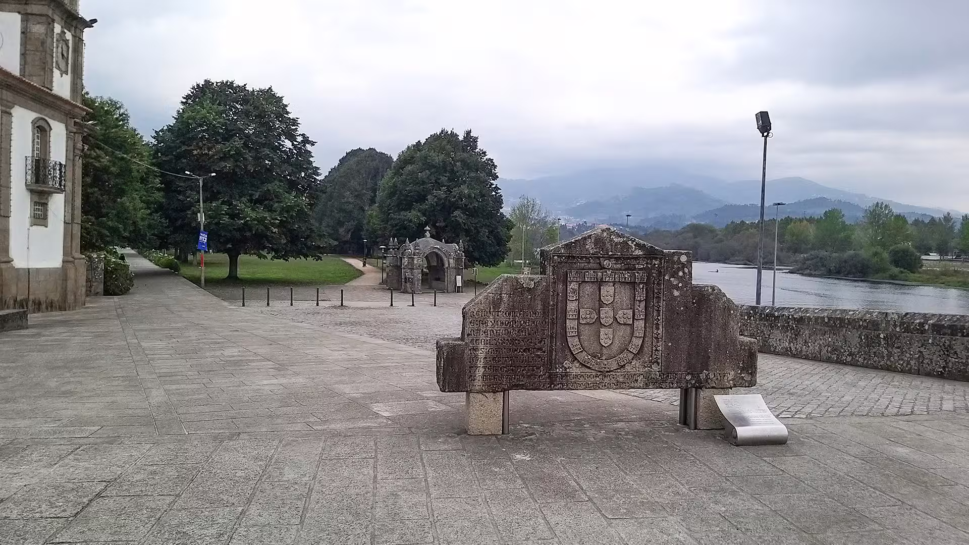 Historic stone monument by the Lima River in Ponte de Lima, Portugal, showcasing Vinho Verde region's scenic beauty.